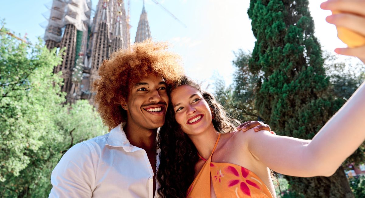 multiethnic couple of tourists visiting Barcelona, Spain and taking selfie